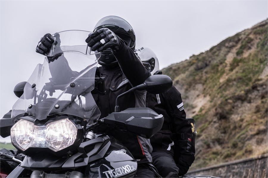 Motorrijder verstelt het windscherm van een motor